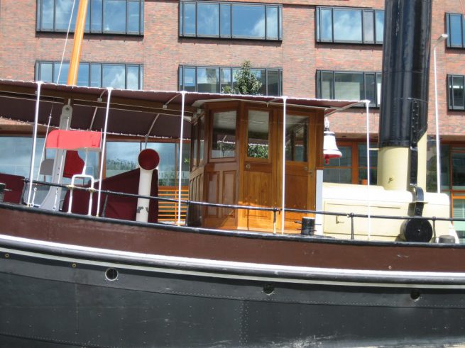 Zijaanzicht van de stuurhut van een stoomsleepboot