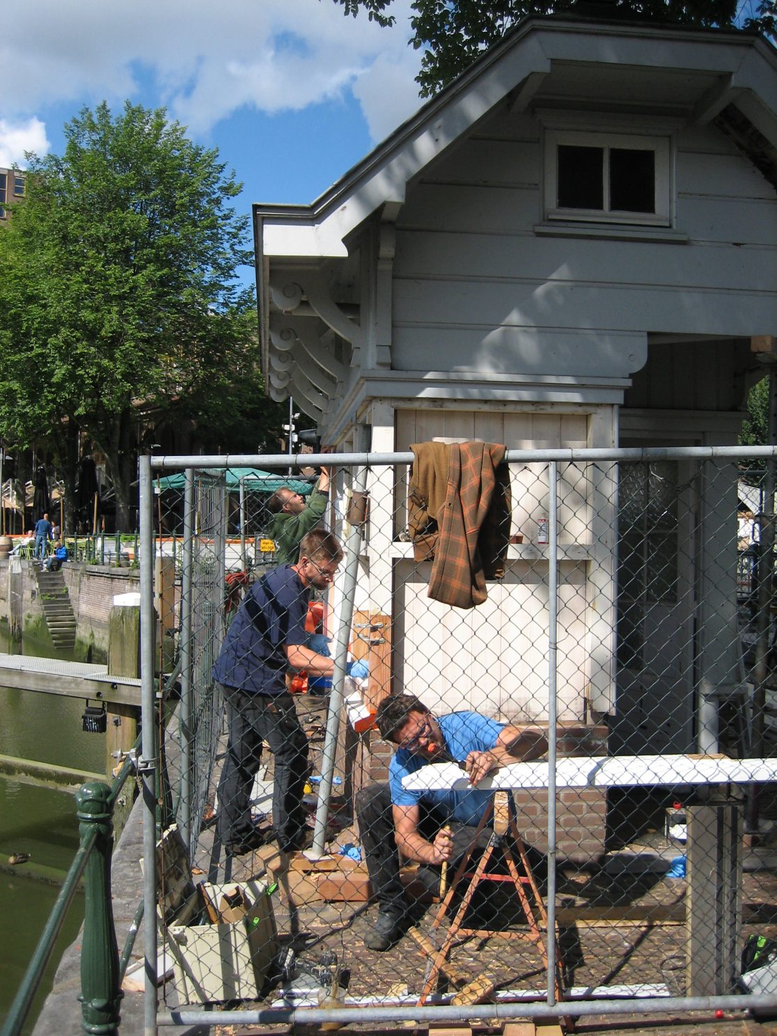 Timmermannen aan het werk aan een brugwachtershuisje
