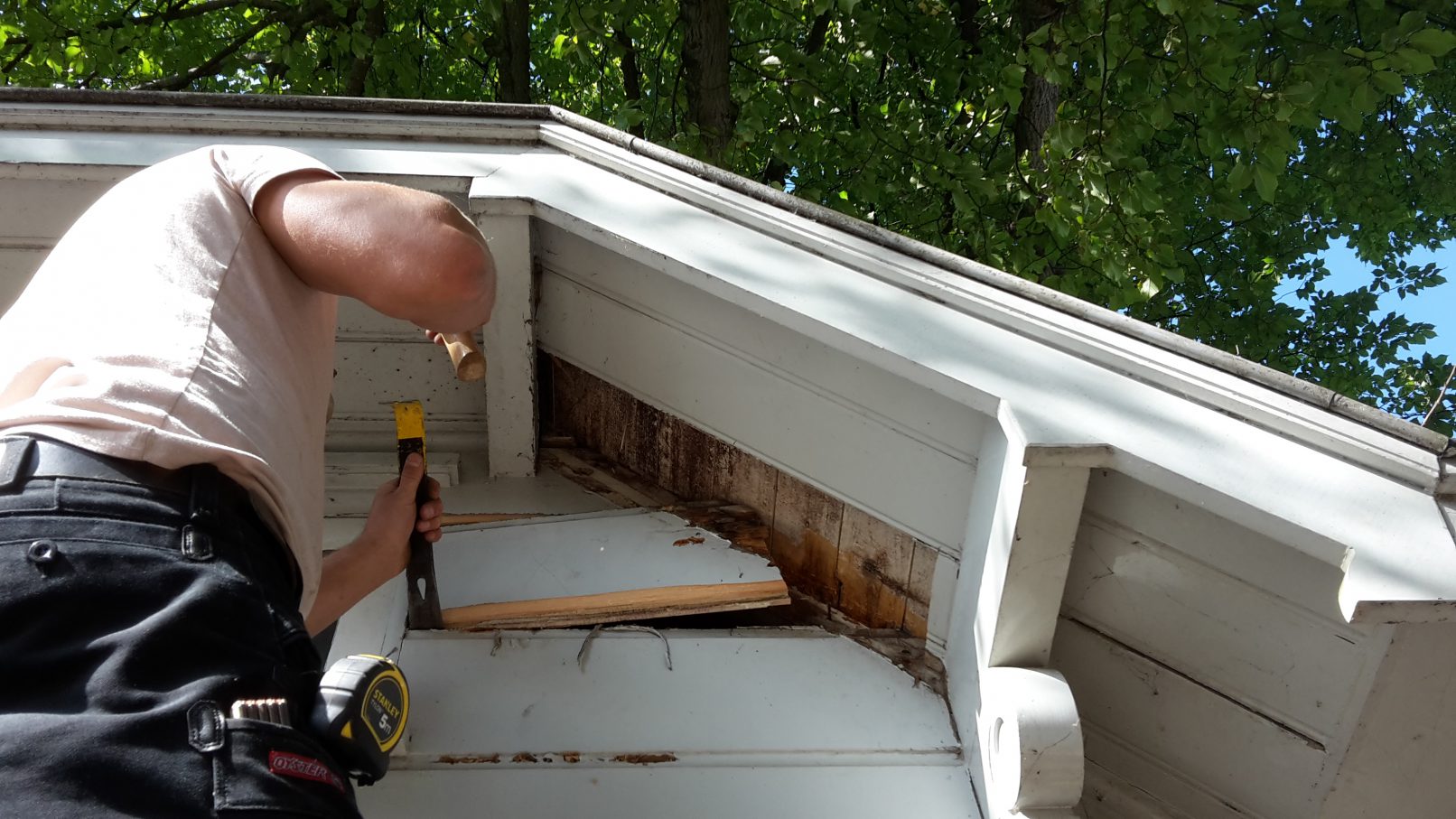 Timmerman demonteert rotte planken van brugwachtershuisje