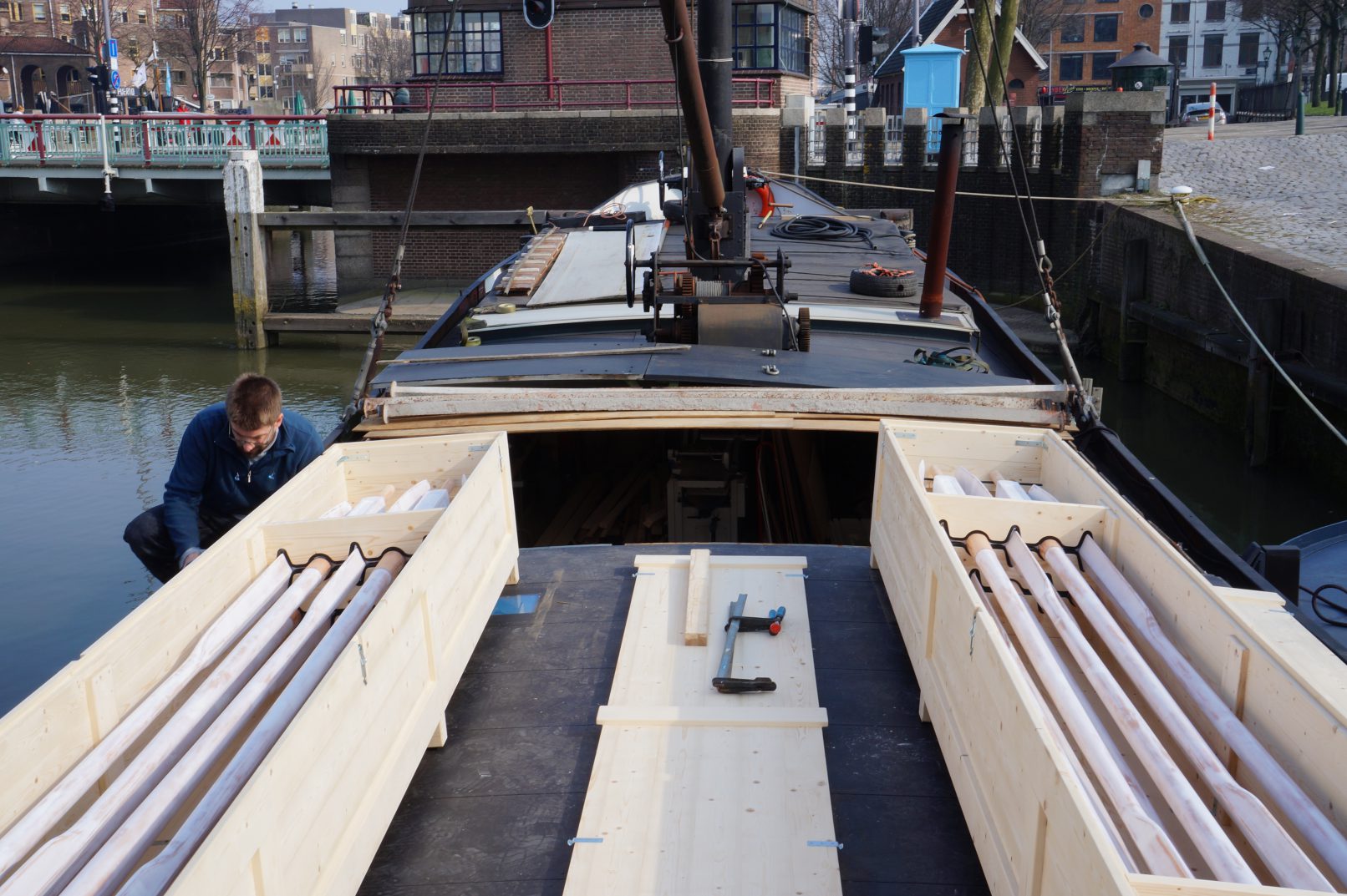 Transportkisten met roeiriemen aan dek van werkschip