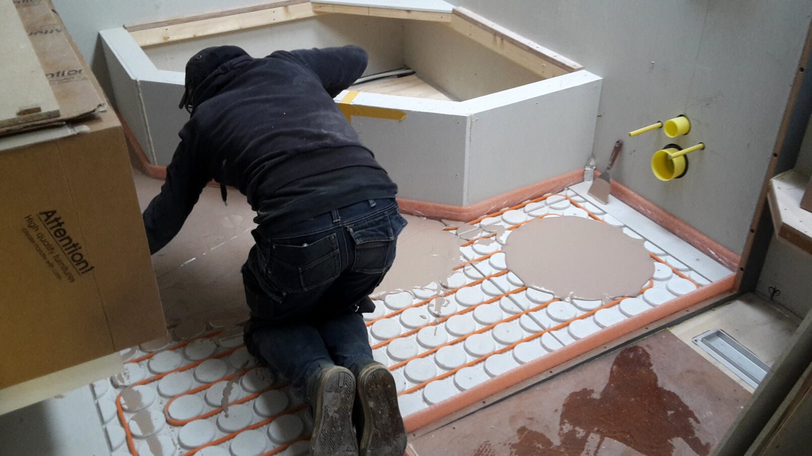 Vakman smeert vloerverwarming op schip af